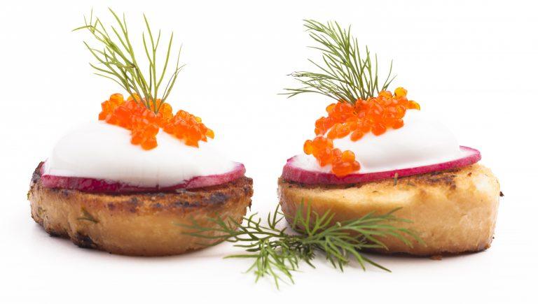 Red caviar on roasted bread and radish isolated on white background